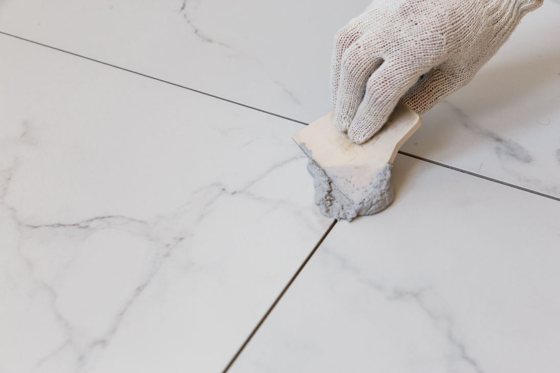 Grouting tiles with a rubber trowel